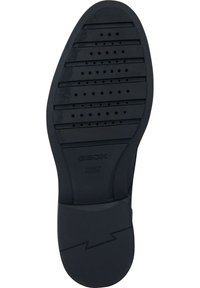 Svart gummisula med vertikala ränder och cirkulära perforeringar. "GEOX ITALIENSK PATENT" präglat på fotvalvet. Platt design, lätt vikt.