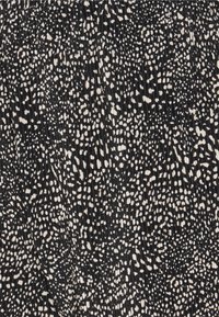 Zwarte stof met een gestructureerd oppervlak, gekenmerkt door een verspreid patroon van witte spikkels. Het ontwerp is lichtgewicht en rekbaar.