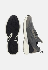 Sivé pletené tenisky s čierno-bielou podrážkou, šnurovanie vpredu, semišové akcenty a textúrovaný vzor protišmykovej podrážky, zobrazené bočné a spodné pohľady.