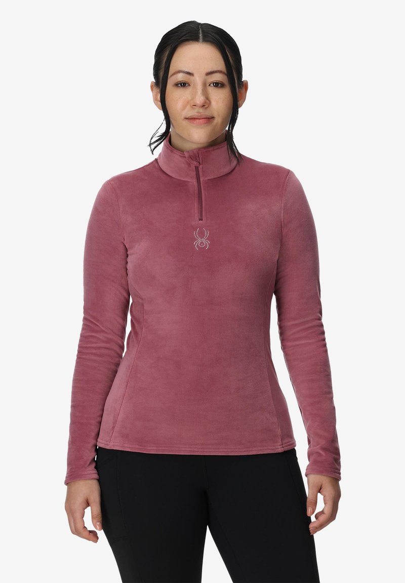 Fleece pullover i støvet rosa med krave med halvvindue. Har et edderkoppelogo på brystet og lange ærmer med en tætsiddende silhuet.