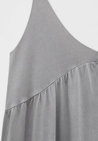 Vestido gris sin mangas con una textura ligeramente estriada, con una sección gathers en el dobladillo inferior y un detalle de costura diagonal.