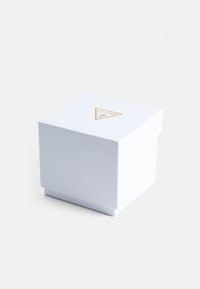 Witte, textuurdoos met een gouden driehoekig logo bovenop. Het heeft een slank, minimalistisch ontwerp en een vierkante vorm.