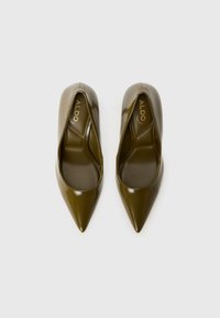 Des chaussures à talon haut en cuir verni vert avec un design à bout pointu et une finition lisse, arborant le logo de la marque à l'intérieur.