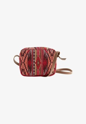 Bolso bandolera rectangular pequeño con patrón geométrico tejido en rojo, rosa y marrón, y una correa larga de cuero color marrón claro.