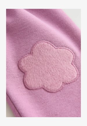 Tela rosa con un gran aplique de fieltro cosido en forma de nube, con una textura suave y bordes en contraste.