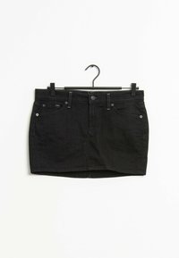 Mini gonna in denim nera con design aderente, cinque tasche e chiusura a bottone. Tessuto morbido con orlo dritto e sottili dettagli di cucitura.