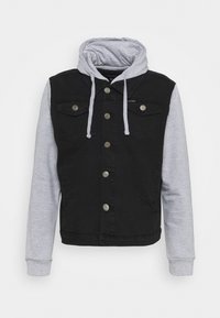 Czarna kurtka dżinsowa z szarą kapturem, zatrzaskami i dwiema kieszeniami na piersi. Charakteryzuje się dopasowanym krojem i kontrastującymi teksturami tkanin.