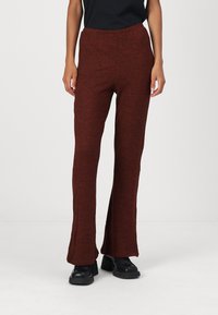 Pantalone s širokim nogavicama od teksturirane tamnocrvene tkanine s elastičnim pojasom. Imaju glatku završnu obradu s suptilnom varijacijom boje.