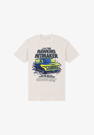 T-shirt crème clair avec une impression graphique d'une camionnette bleue et jaune, accompagnée du texte « Call the Hawkins Hitmaker » au-dessus et d'un slogan en dessous.