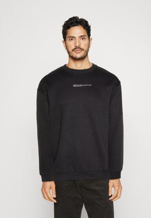 Sort sweatshirt lavet af bomuld, med lange ærmer, en rund halsudskæring og trykt tekst "DENIM" over "TOM TAILOR" på brystet.