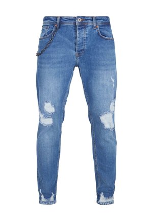 Blaue Denim-Jeans mit slim fit, die eingearbeitete Abnutzungsstellen, ausgefranste Säume und einen Kettenakzent im Bereich der vorderen Tasche aufweisen.