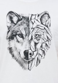 Η μισή πλευρά του προσώπου ενός λύκου απεικονίζεται ρεαλιστικά στα αριστερά, ενώ η δεξιά πλευρά απεικονίζεται με ένα γεωμετρικό, αφηρημένο ασπρόμαυρο μοτίβο σε λευκό φόντο.