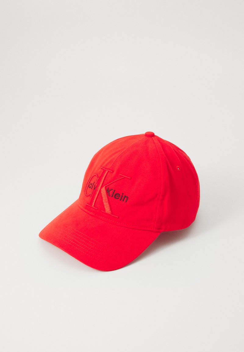 Rode baseballcap met verstelbare band, voorzien van geborduurd "CK" logo in zwart aan de voorkant en een effen kleur over de hele cap.