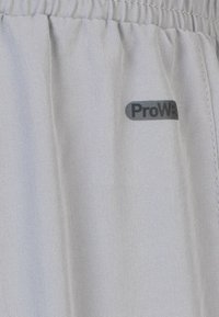 Grijze, lichte stoffen broek met een elastische tailleband. Heeft een zwart "ProW3" logo aan de zijkant. Gladde textuur en casual ontwerp.
