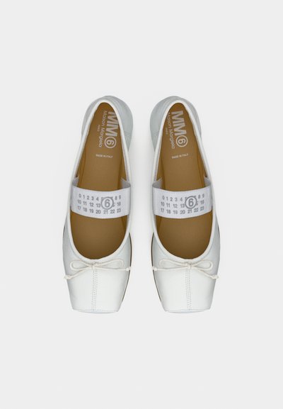 Άσπρα δερμάτινα μπαλαρίνα με ελαστικό λουράκι που φέρει αριθμούς και περιγεγραμμένο το "6", διακόσμηση με φιόγκο στα δάχτυλα, και καφέ πάτοι με την επιγραφή "MM6 Maison Margiela".