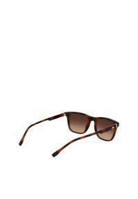 Okulary przeciwsłoneczne w kolorze biszkoptowym z gradientowymi brązowymi soczewkami. Kwadratowy kształt, grube plastikowe oprawki i subtelny akcent logo na zauszniku.