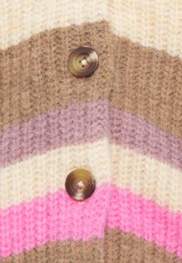 Gebreide cardigan met een zigzagpatroon in bruin, beige, lavendel en roze. Opmerkelijke details zijn twee grote, ronde knopen.