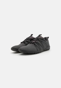 Scarpe da ginnastica nere con una parte superiore in mesh traspirante, design testurizzato, suola flessibile e chiusura con lacci con dettagli riflettenti.