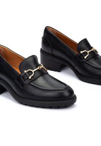 Mocassins en cuir noir avec un petit talon block, dotés d'un accent en métal doré et de détails de couture subtils sur le dessus.