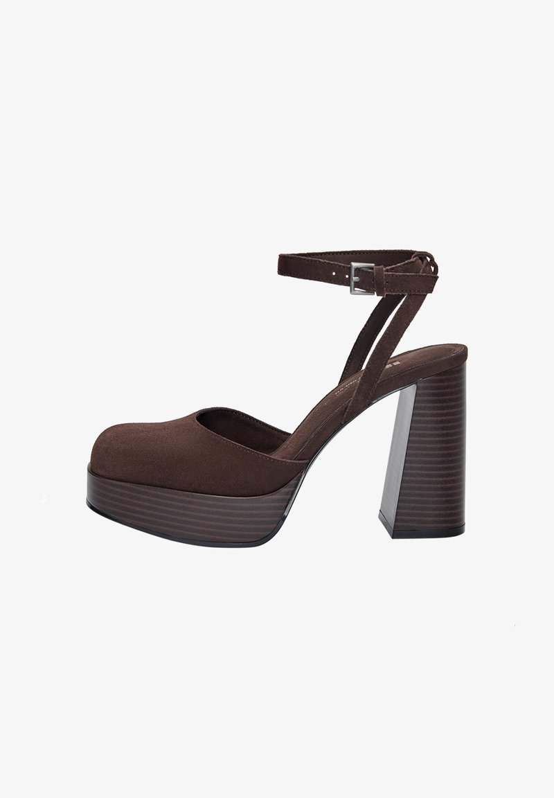 Brown suede platform shoe with a rounded toe, ankle strap, and a high block heel featuring vertical grooves.