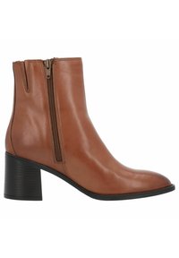 Bota de cuero marrón hasta el tobillo con punta redonda, cremallera lateral y un tacón negro apilado. Textura suave con sutiles detalles de costura.