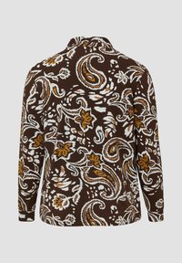 Braunes langärmliges Hemd mit weißen, senfgelben und tanfarbenen Blumen- und Paisley-Mustern, von hinten auf einem einfarbigen hellgrauen Hintergrund gezeigt.