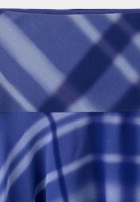 Tissu bleu avec un motif de rayures croisées bleu clair et blanc créant un motif à carreaux.