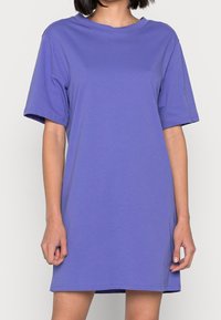 Fioletowa sukienka t-shirt z krótkim rękawem i okrągłym dekoltem, wykonana z gładkiego materiału, charakteryzująca się luźnym krojem i prostym wykończeniem.