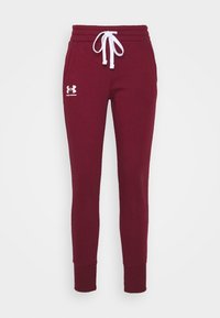 Burgunderfarbene Jogginghosen mit elastischem Bund und verstellbarem weißen Kordelzug. Mit einem weißen Logo am linken Oberschenkel und gerippten Säumen.