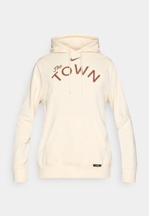 Cremefarbener Hoodie aus weichem Stoff mit einer Vordertasche, Kapuze mit Kordelzug und auffälliger dunkelroter Aufschrift "The TOWN" mit Nike-Logo.