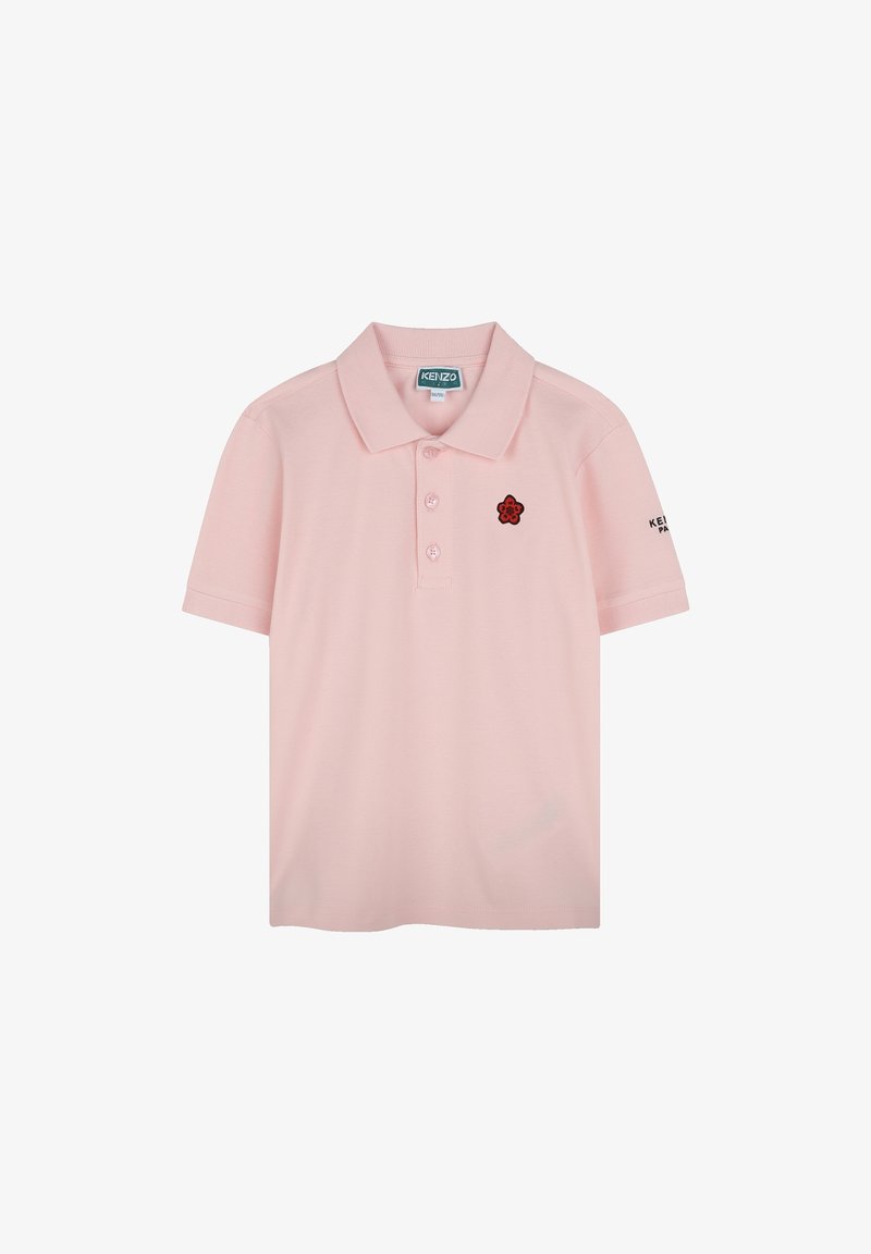 Polo en rose clair, en coton, avec un col à trois boutons, des manches courtes et un logo de fleur brodé noir sur la poitrine.