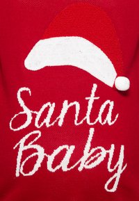 Red sweater featuring a white Santa hat graphic and "Santa Baby" text in a scripted font. Knitted texture with distinct patterns.