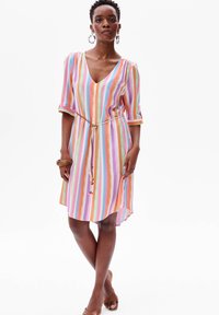 Sukienka do kolan w paski, z pionowymi, wielokolorowymi paskami w odcieniach różu, pomarańczu i niebieskiego. Dekolt w kształcie litery V, krótkie rękawy oraz wiązanie w talii.