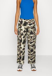 Spodnie cargo w kamuflażu w odcieniach zieleni, brązu i czerni. Wykonane z luźnego materiału, z dużymi kieszeniami i średnim stanem.