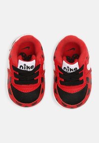 Červené a černé dětské tenisky s hravým puntíkovaným vzorem, zdobené bílými akcenty, černými tkaničkami a měkkou vnitřní podšívkou.