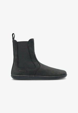 Bottine noire à enfiler avec panneaux latéraux élastiques, languette à l’arrière et semelle peu rainurée, conçue pour un usage décontracté.