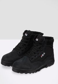 Bottes montantes noires Fila avec fermeture à lacets sur le devant, col rembourré et logo sur la languette et le côté, conçues pour une utilisation extérieure robuste.