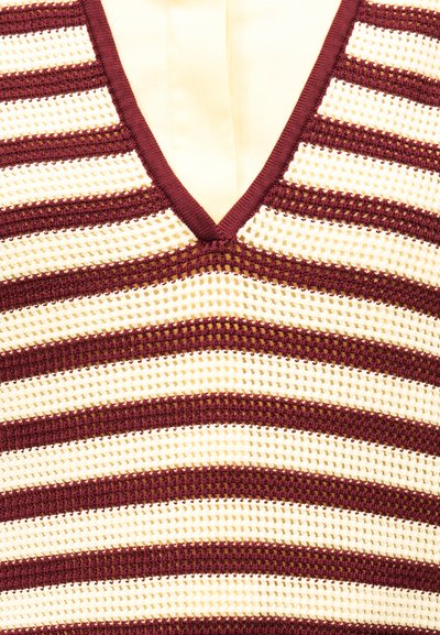 Gros plan sur un haut en tricot sans manches avec des rayures horizontales bordeaux et crème et un décolleté en V.
