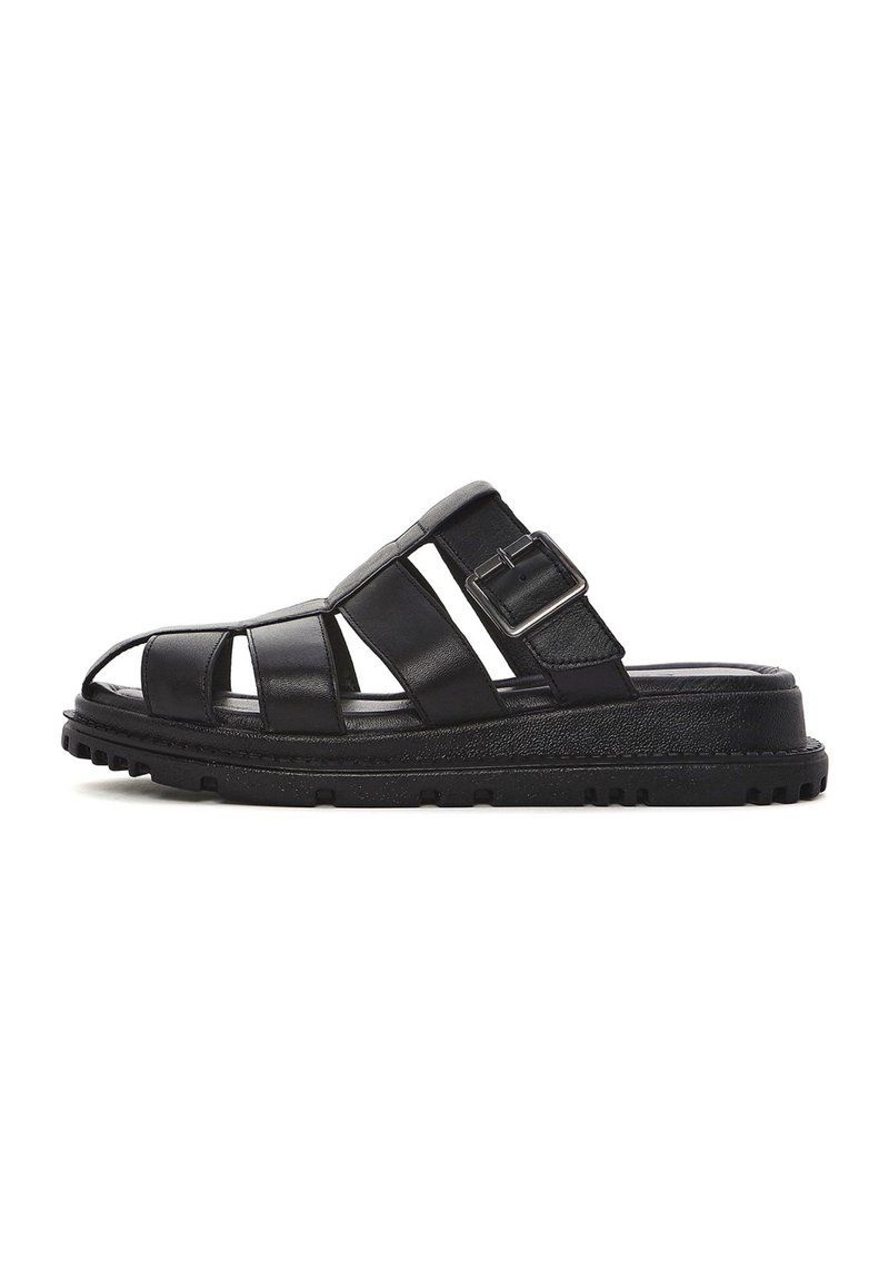 Sandalo in pelle nera con punta aperta, design a più cinghie, una fibbia laterale e una suola in gomma nera testurizzata. Presenta un profilo piatto.