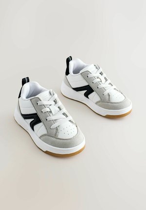 White and gray sneakers with a suede and synthetic upper, featuring black accents, lace closure, and a rubber sole with a textured finish.