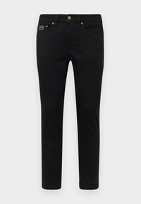 Melnas denim bikses ar šaurlu piegriezumu, ar pogu aizdari, piecām kabatām un zeltītām detaļām. Audums ir gluds ar vienkāršu dizainu.