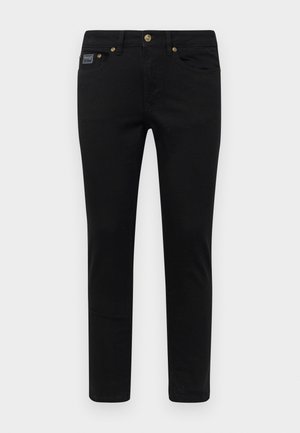 Black denim pants with a slim fit, featuring a button closure, five pockets, and golden hardware accents. The fabric is smooth with a solid design.