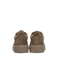 Brown suede sneakers with a low profile, thick rubber soles, and a textured finish. Features padded heel and stitching accents.