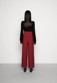 Vida burgunderbyxor med vida ben i slät tyg, med hög midja, sidofickor och en ren, skräddarsydd finish.