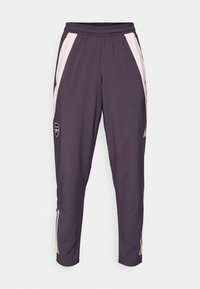 Dunkelviolette Sporthose mit weißen Seitenstreifen und elastischem Bund. Mit einem kleinen Logo nahe dem linken Oberschenkel. Glattes, leichtes Material.