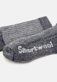 Tumed ja valged triibulised sokid tekstuuriga kangast, mis on varustatud tugevdatud varbaga ja külgedele kootud logoga, tavalise crew pikkusega.