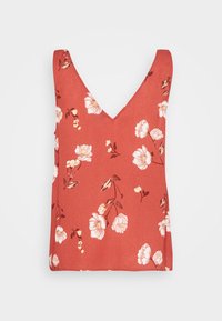 Haut sans manches couleur rouille avec imprimés floraux blancs et rose pâle, et un profond décolleté en V.