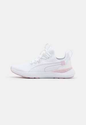 Witte en lichtroze Puma hardloopschoen met vetersluiting, gevoerde zool en trekhaken op de tong en hiel, zijaanzicht op een witte achtergrond.