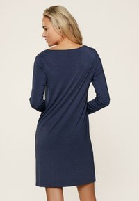 Robe longue à manches longues bleu marine, en tissu léger, col rond, coupe légèrement ample, longueur genou, avec une texture lisse et un minimum de détails.