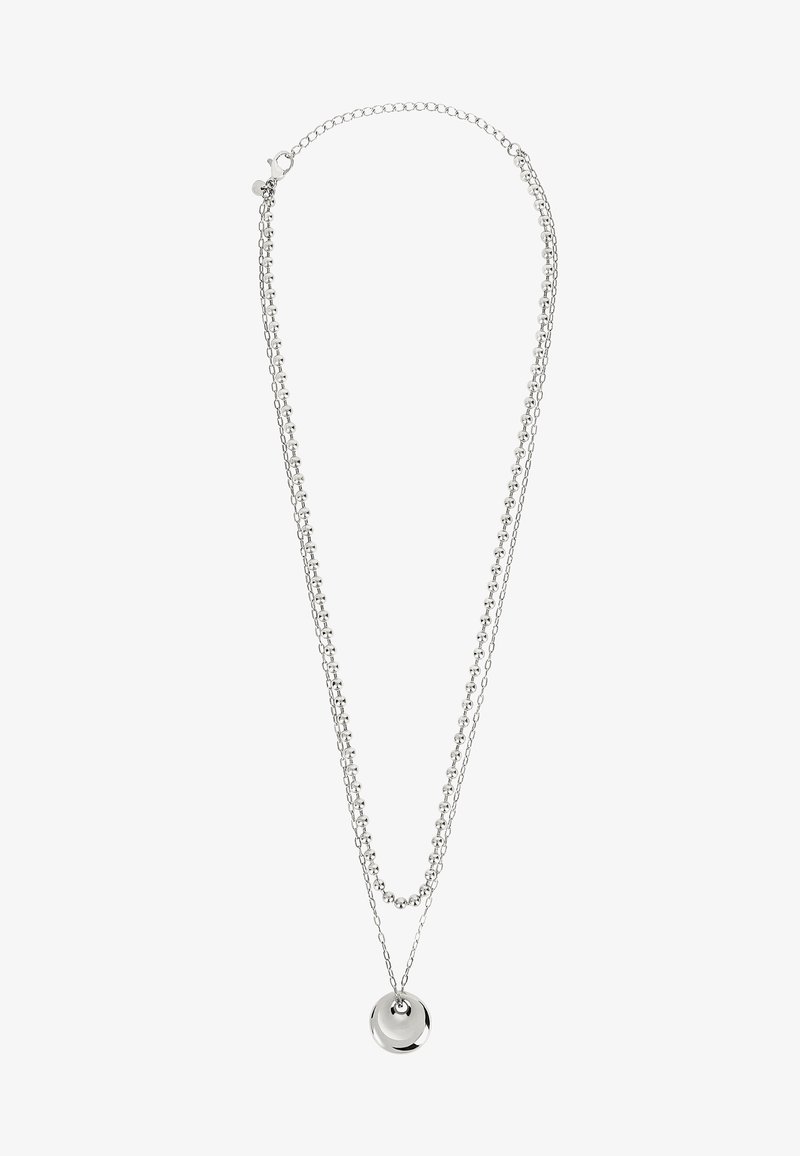 Collier en chaîne argentée avec deux brins superposés ; l'un présente des perles rondes, tandis que l'autre a un pendentif circulaire lisse.